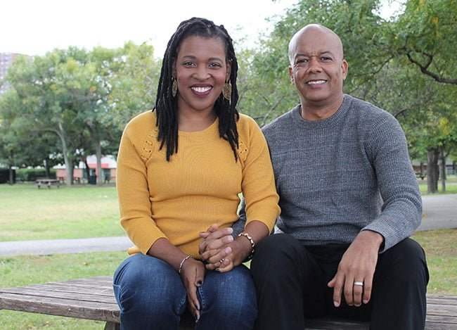 A happy Black couple posing in a park