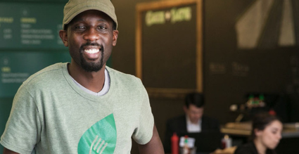 man posing in restaurant with patrons in background